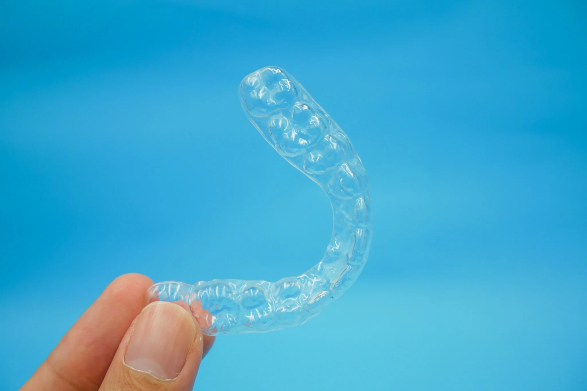 Transparent dental mouthguard retainer against blue background