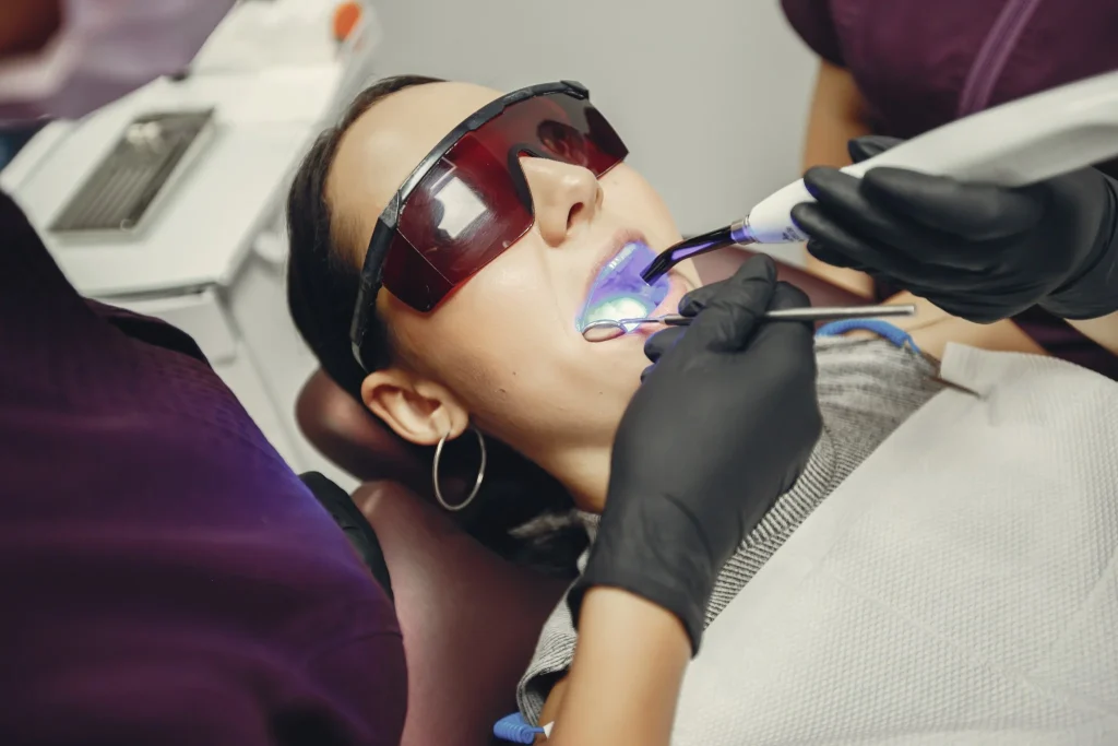 Patient wearing protective glasses during professional dental cleaning