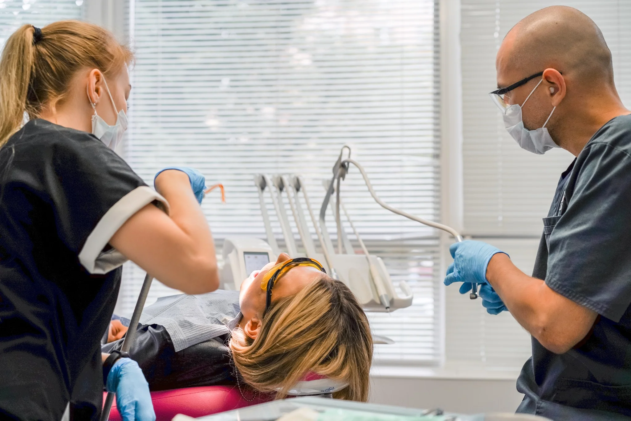 Pediatric dentist treating child tooth using rubber dam technique