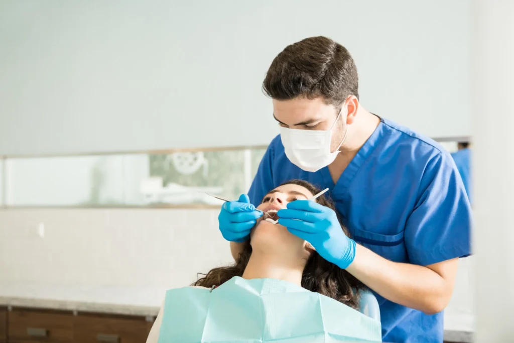 Dentist examining young woman during dental consultation