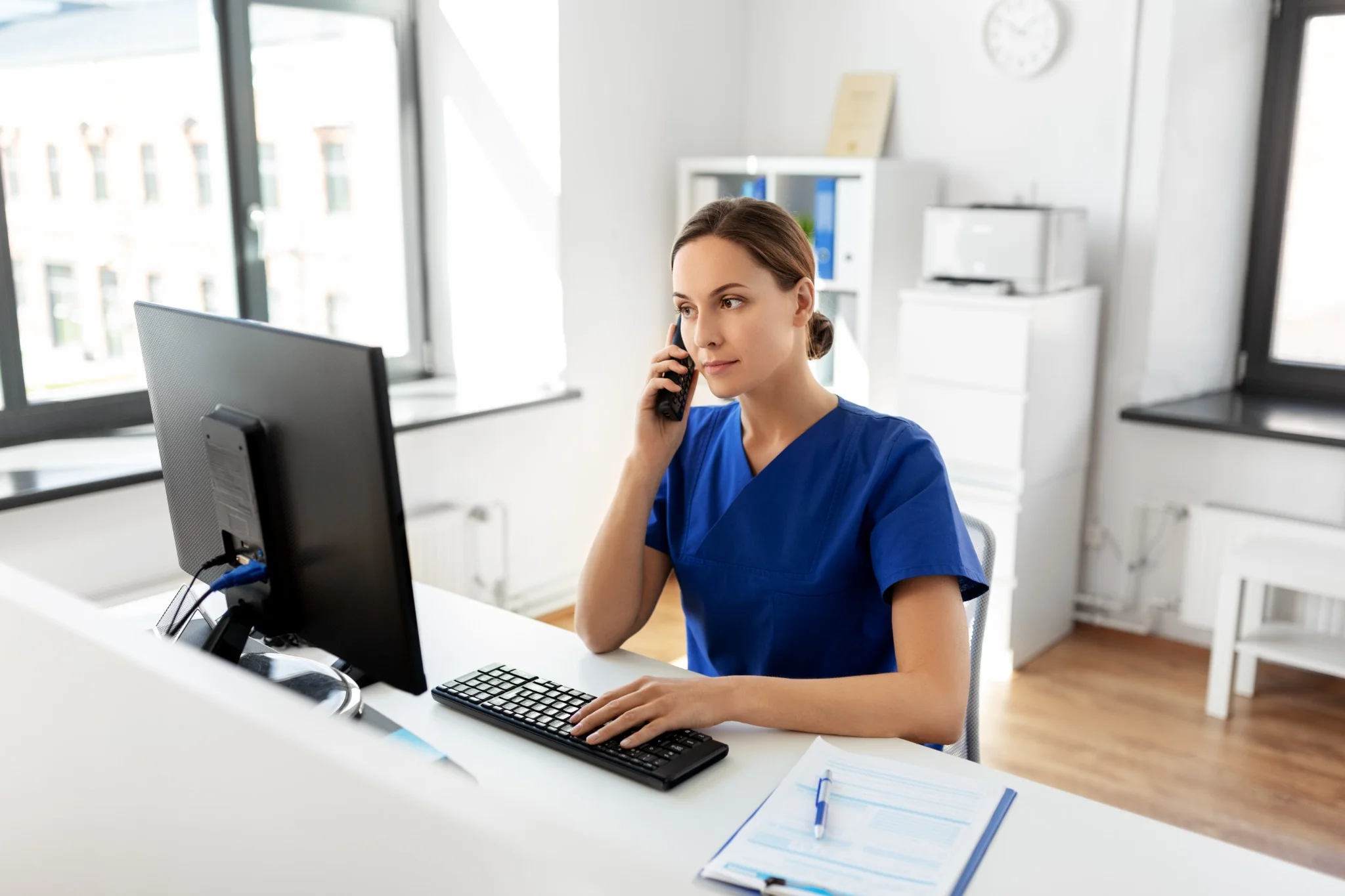 Friendly front desk staff answering calls at One Dental Place Fresno dental office